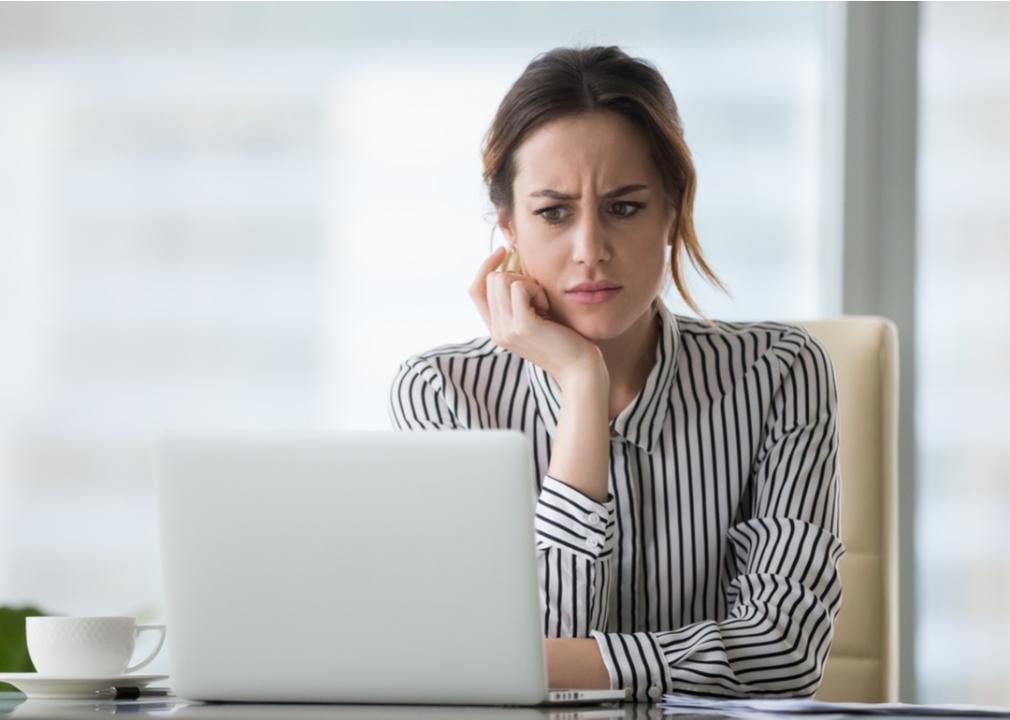 Woman looking at computer with confused expression.