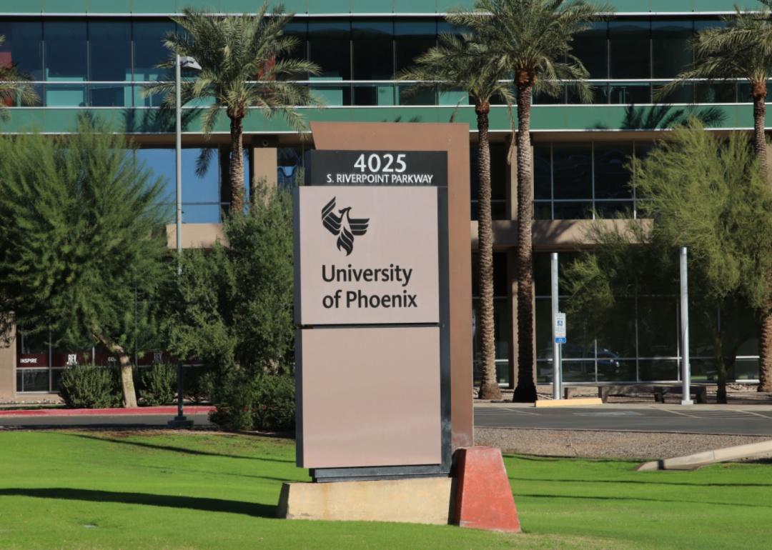 A green lawn and palm trees in front of the University of Phoenix.