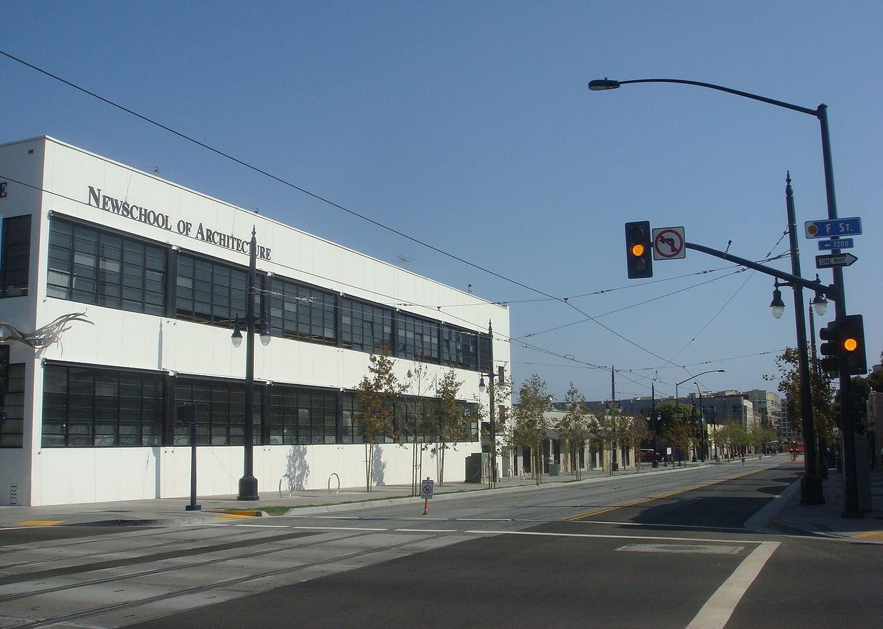 A white building with dark windows and a sign for Newschool of Architecture.