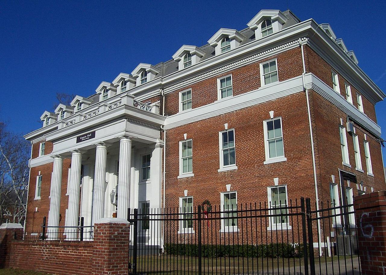 A red brick historic building with white Greek columns and detailing.