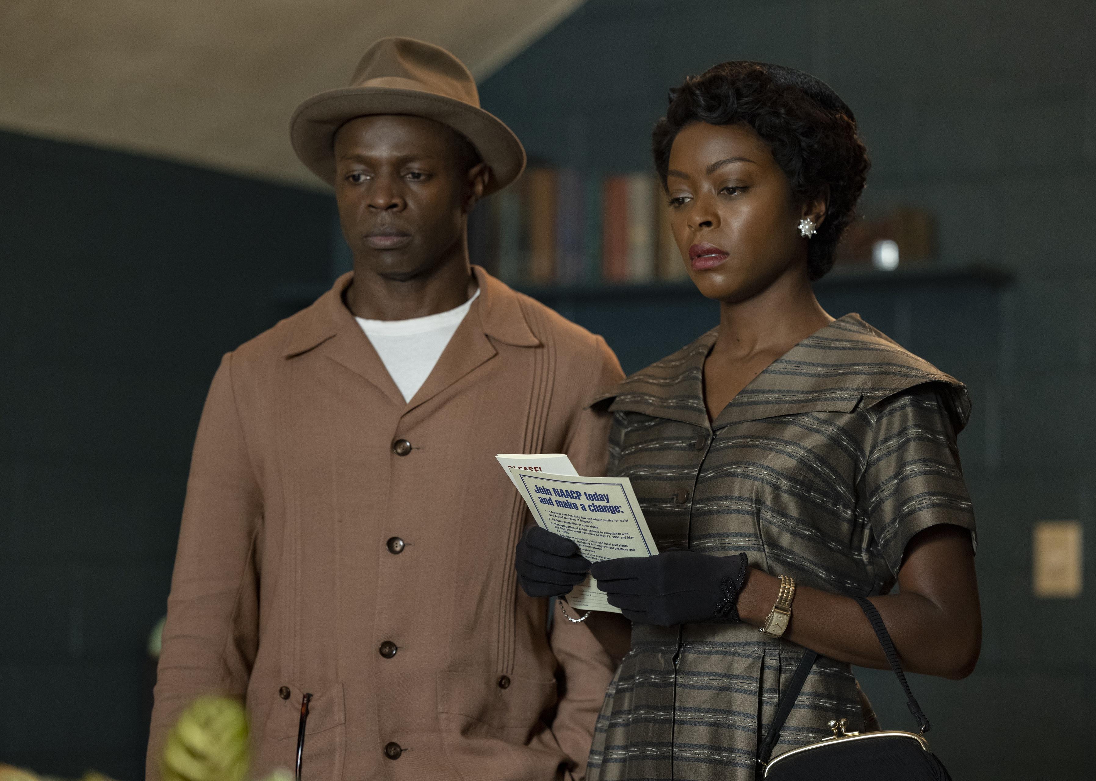 A black man standing with a black woman holding a NAACP pamphlet.