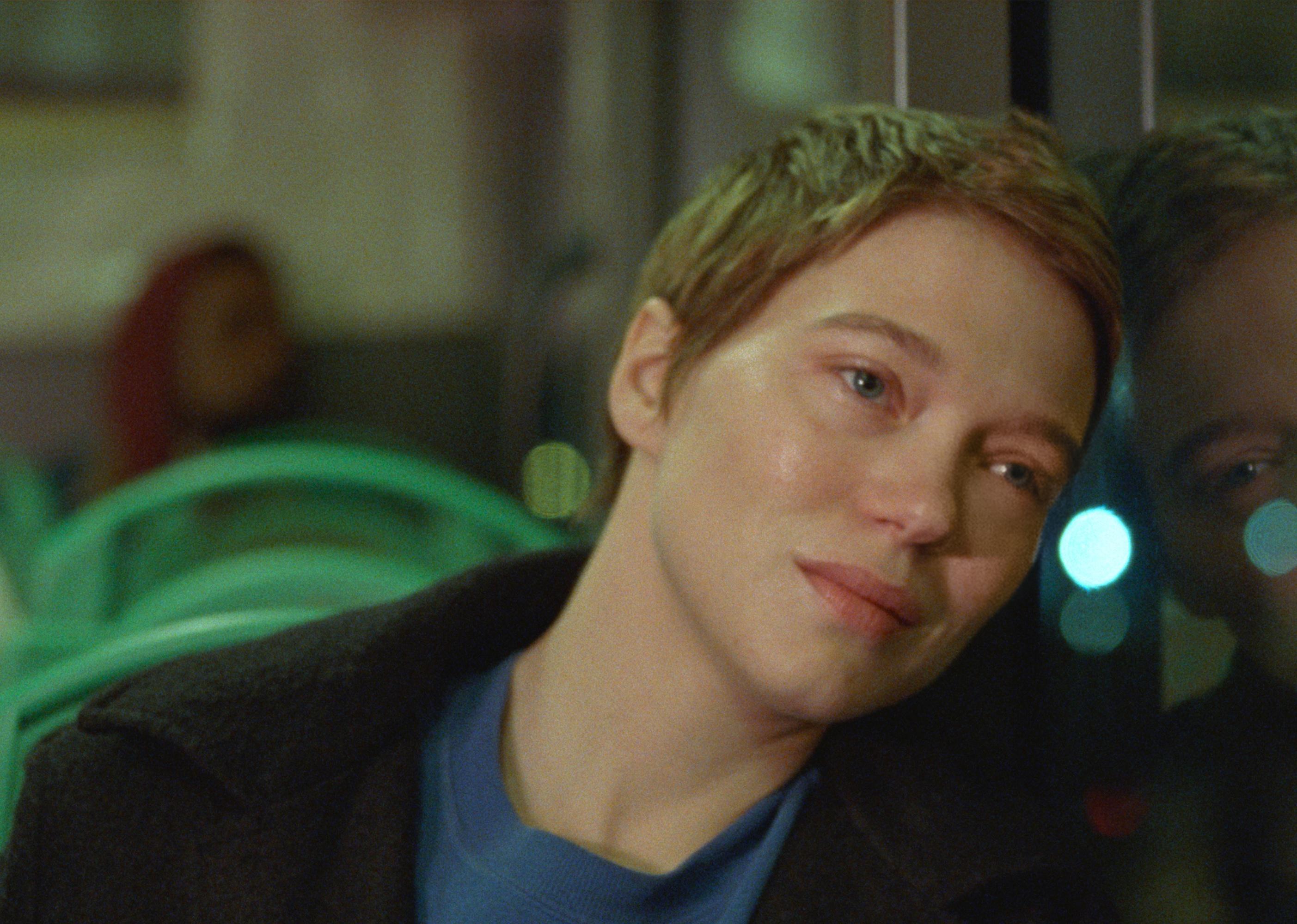 A woman in a seat leaning her head against a glass window.