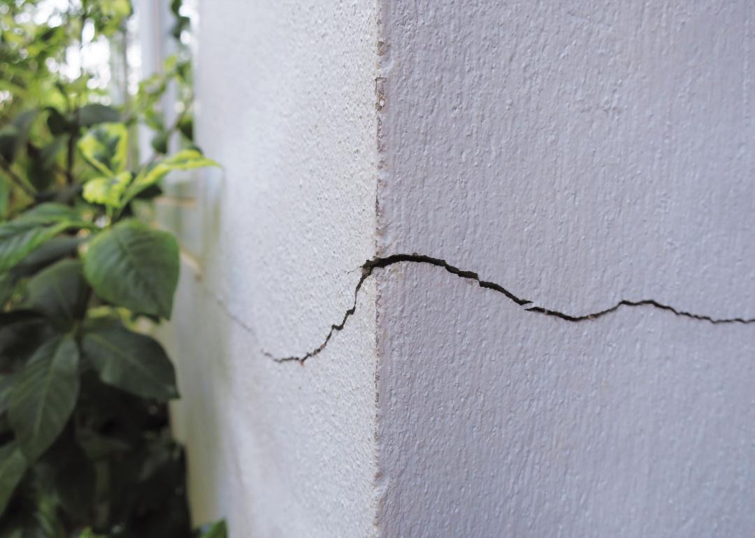 A big crack in the side of a concrete structure.