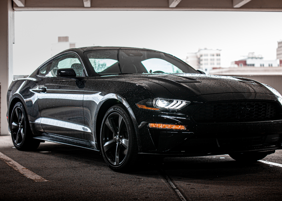 A black Ford Mustang Coupe in a parking garage.