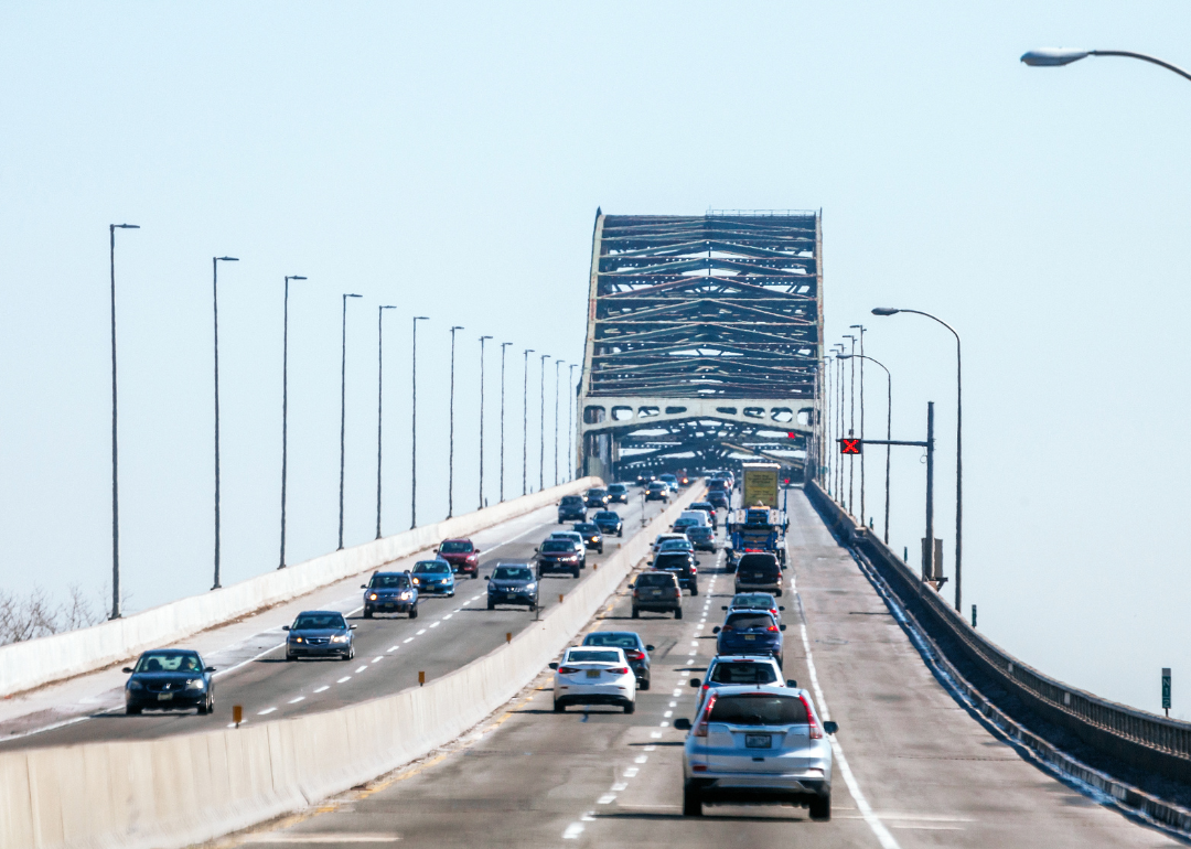 Cars driving across a tall bridge.
