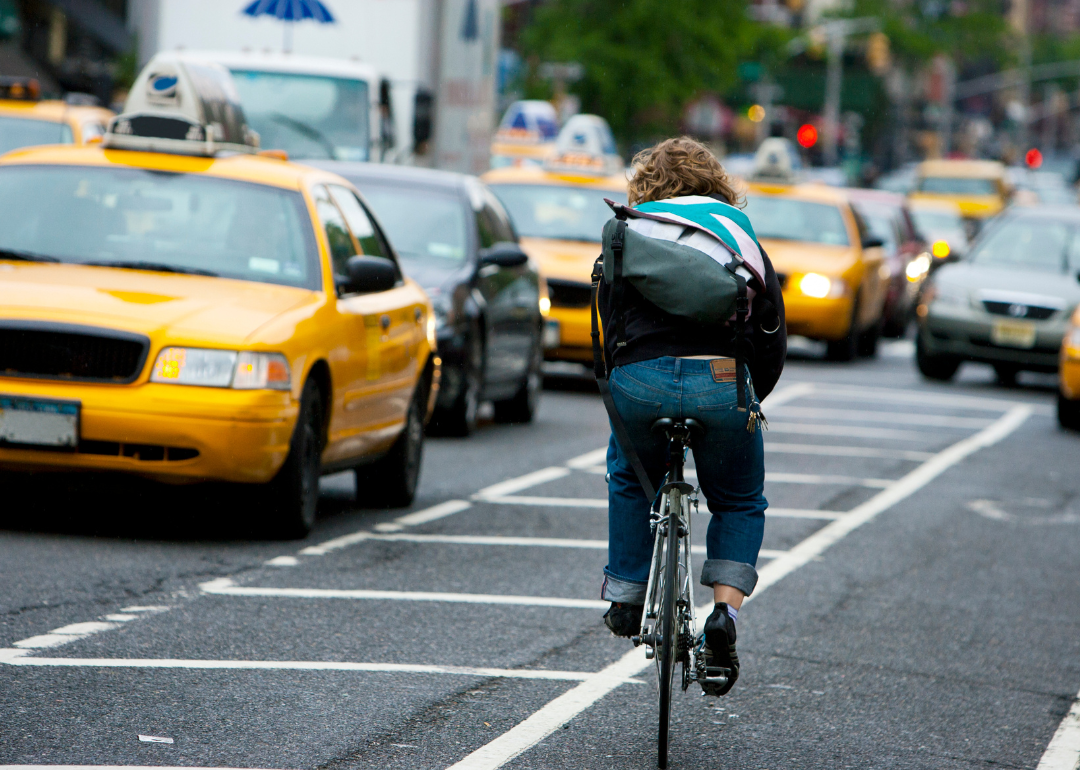 A cyclist riding through heavy traffic.
