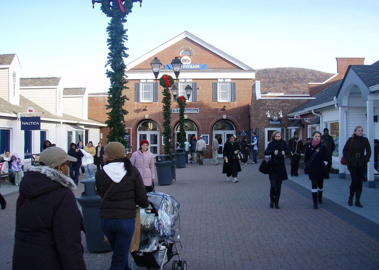 A crowded brick and wood outdoor shopping mall.