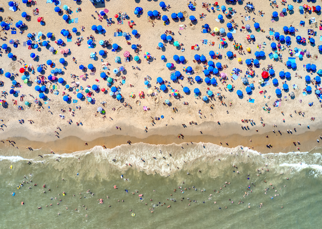Rehoboth Beach view from above with umbrellas and colorful beachgoers.