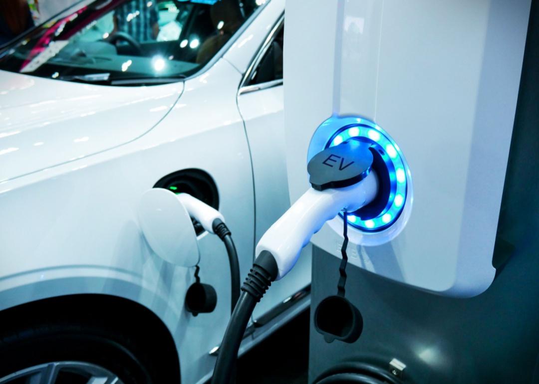 A closeup of a white vehicle charging.