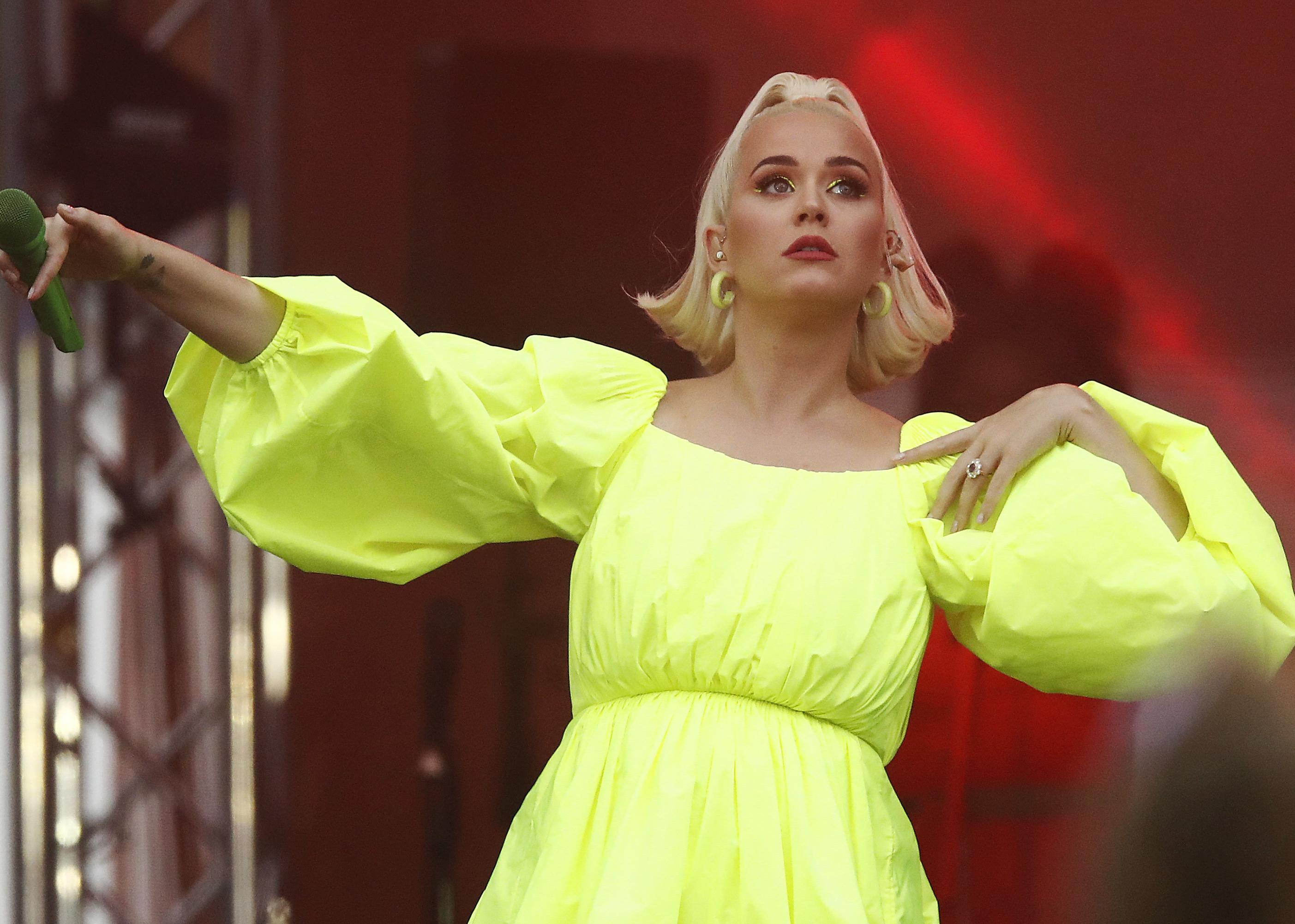 Katy Perry performing in a bright yellow dress on stage.