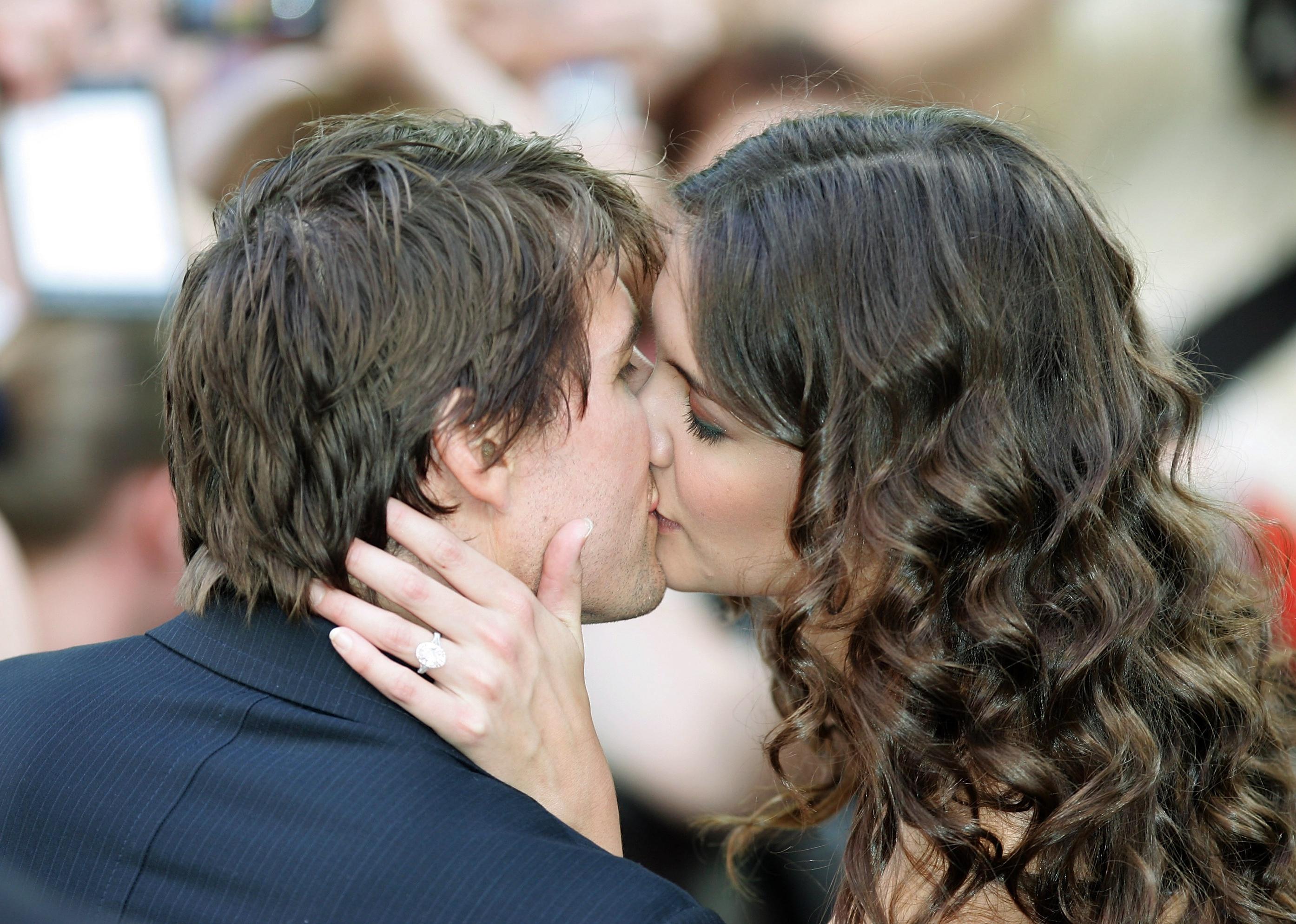 Katie Holmes and Tom Cruise kissing with her hand over his neck showing her ring.