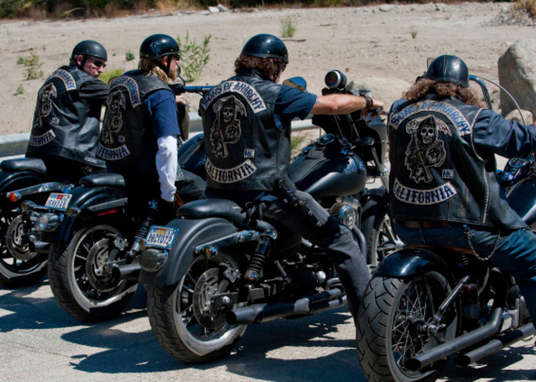 Four men on motorcycles in a row wearing Sons of Anarchy jackets.