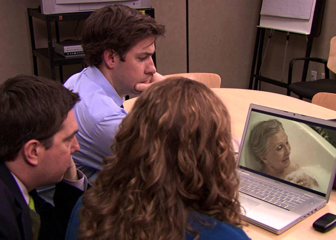 John Krasinski, Ed Helms and Jenna Fischer look at a laptop showing a video of a woman in a bubble bath.