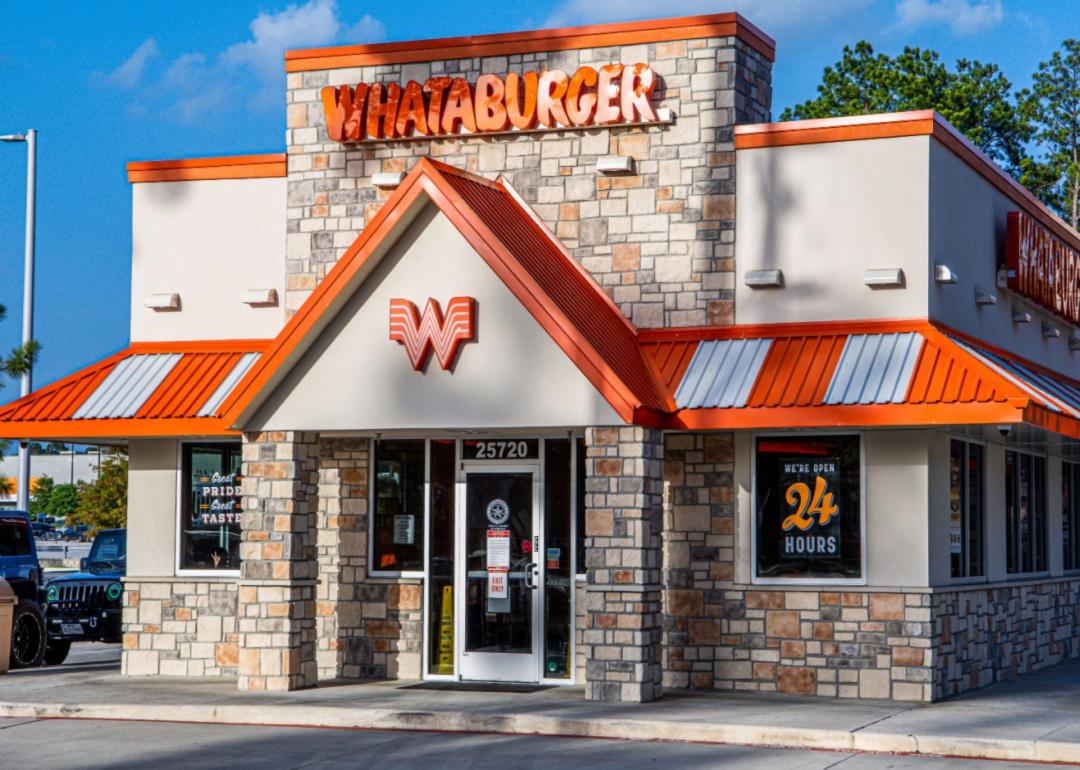 A stone Whataburger restaurant with an orange and white striped awning.