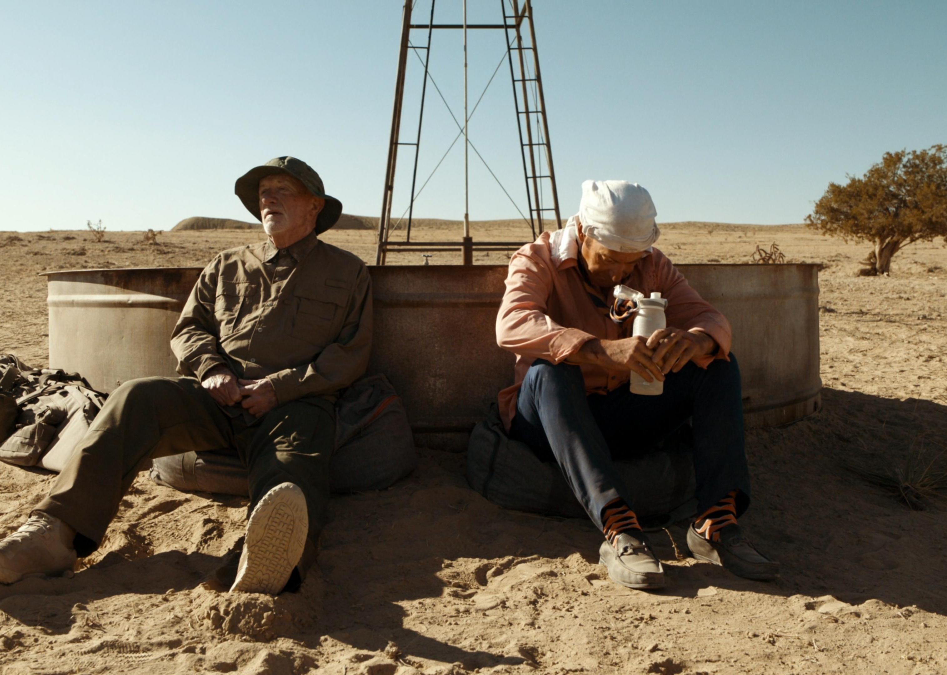 Jonathan Banks and Bob Odenkirk in the blazing sun in front of a water trough and windmill.