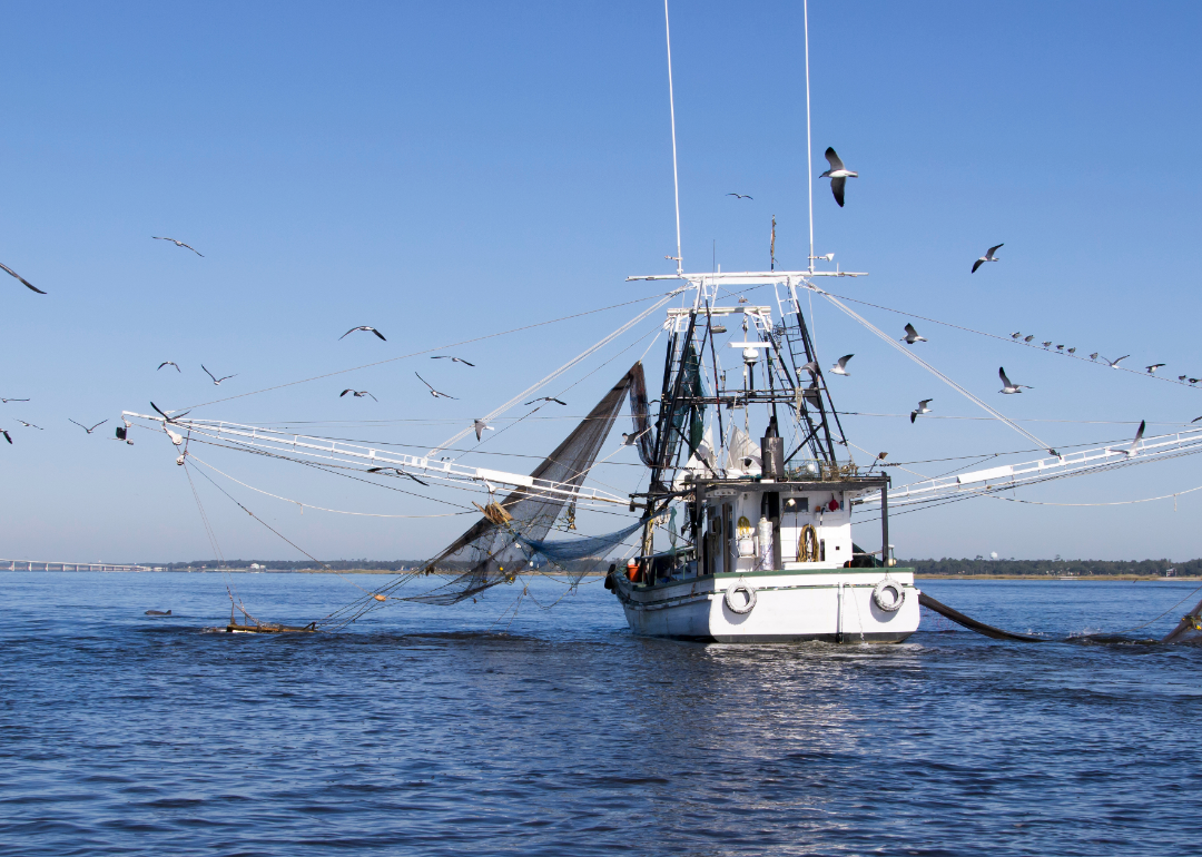 A fishing boat with nets dropped in the open water.