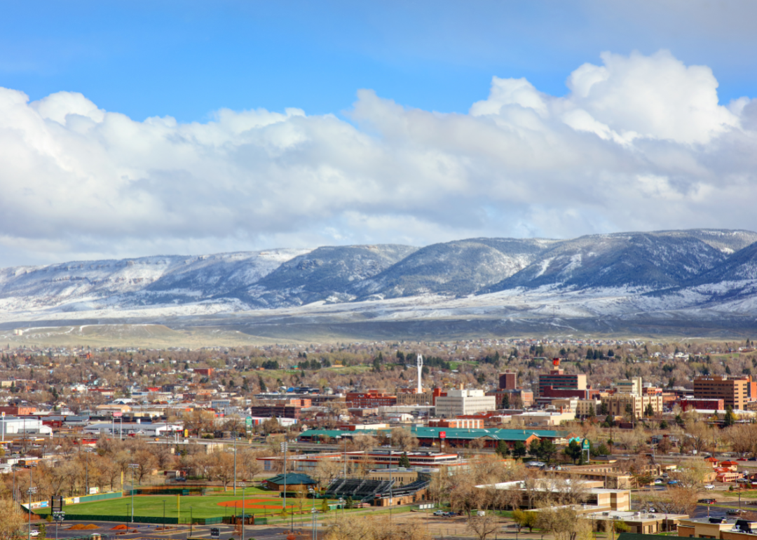 Casper Wyoming downtown with snow capped mountains in the distance and and a baseball field in the foreground.
