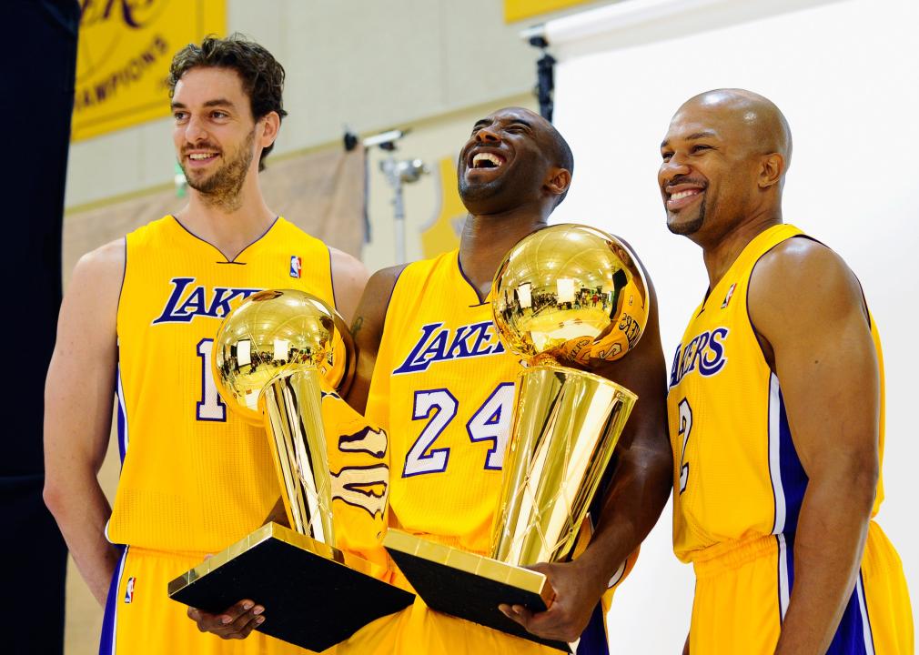 Kobe Bryant laughs as he holds two NBA Finals Trophy