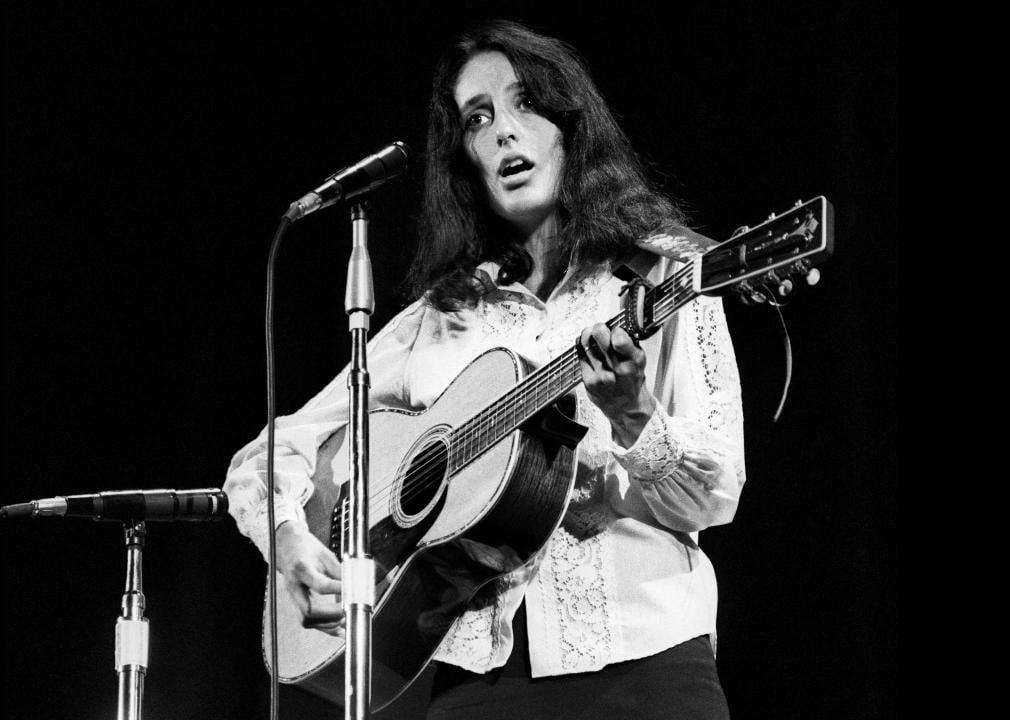Joan Baez performing with guitar onstage.