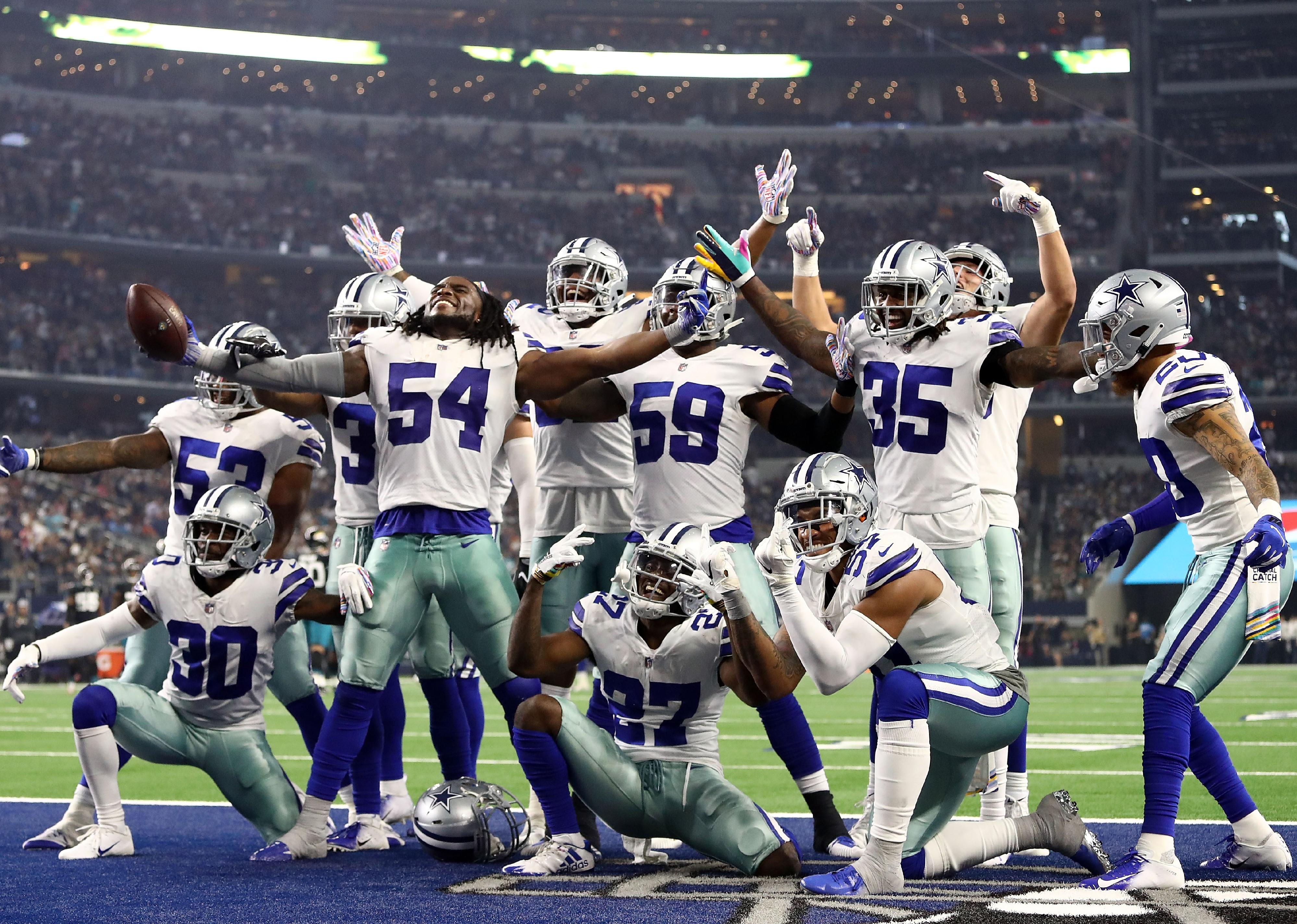 The Dallas Cowboys defensive line celebrates a fumble recovery.