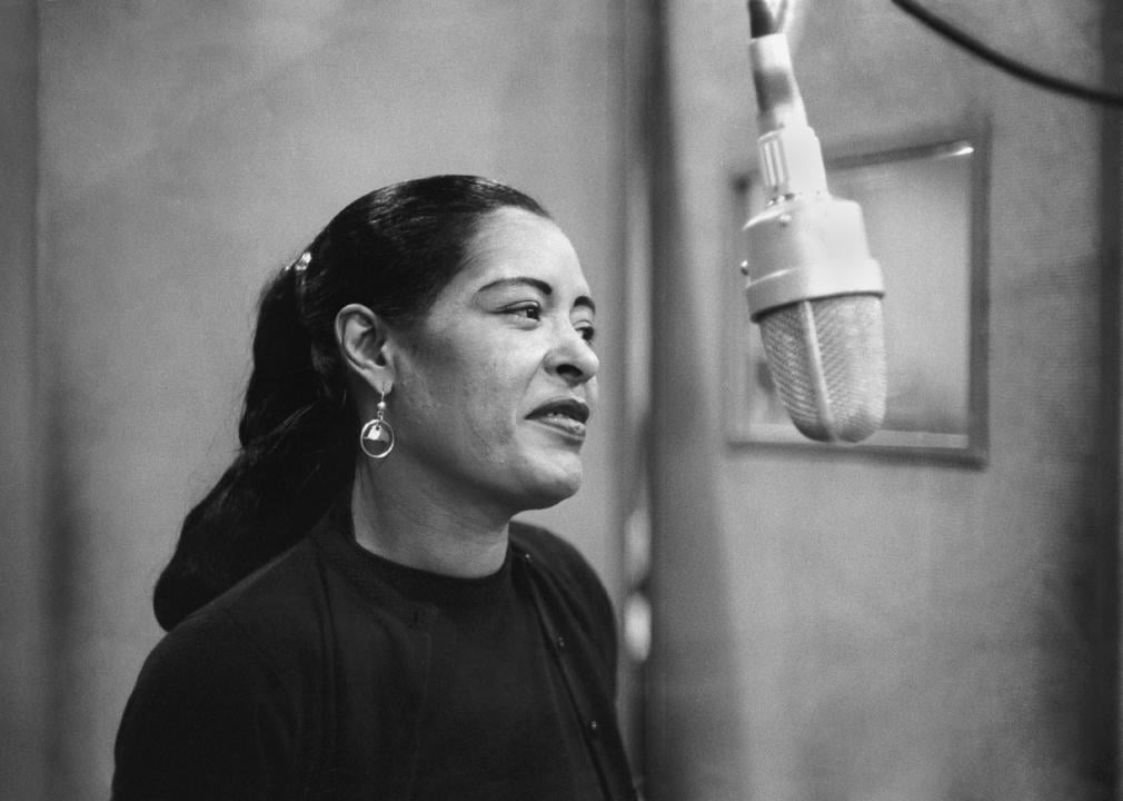 Billie Holiday singing in recording booth.