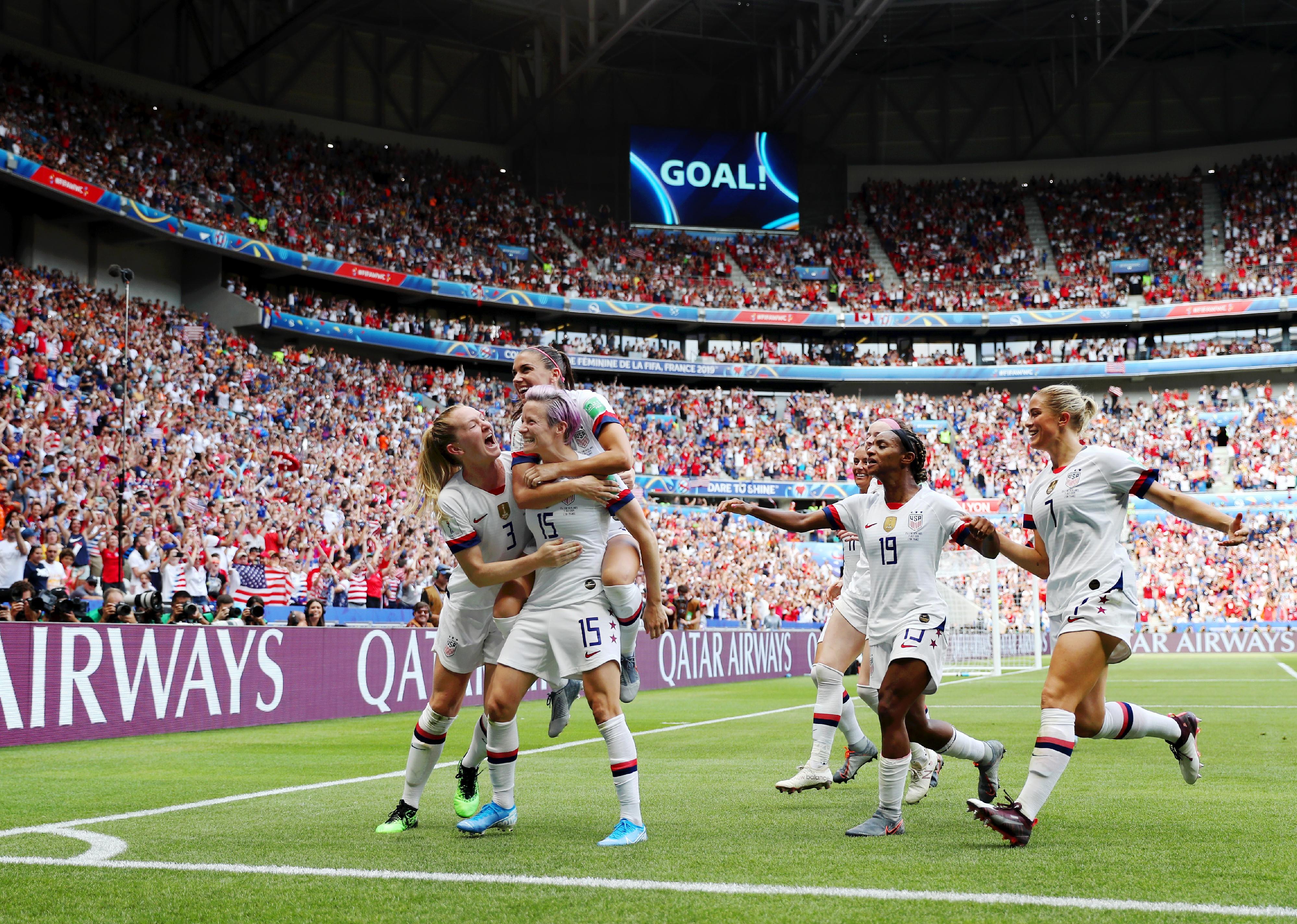 Megan Rapinoe celebrates with teammates after scoring a goal 