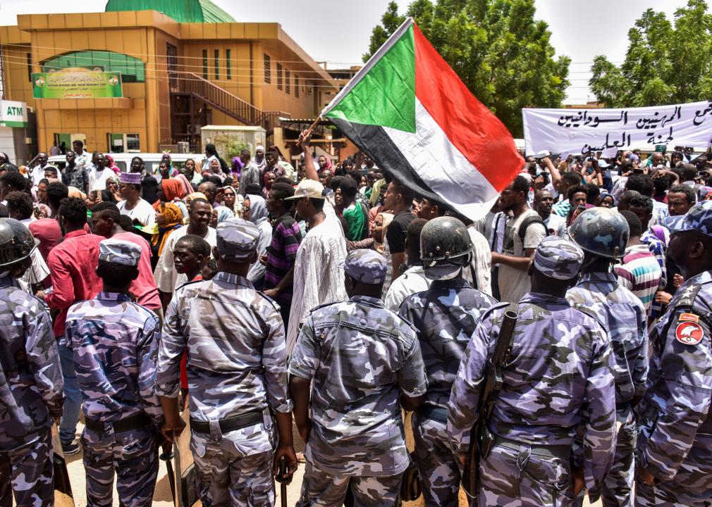 Sudanese security forces stand by as demonstrators march