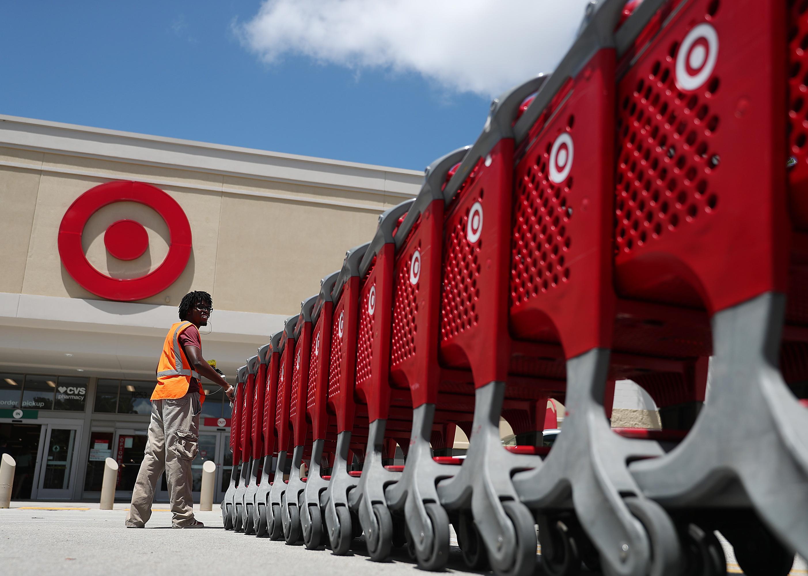 A Target store employee collects shopping carts