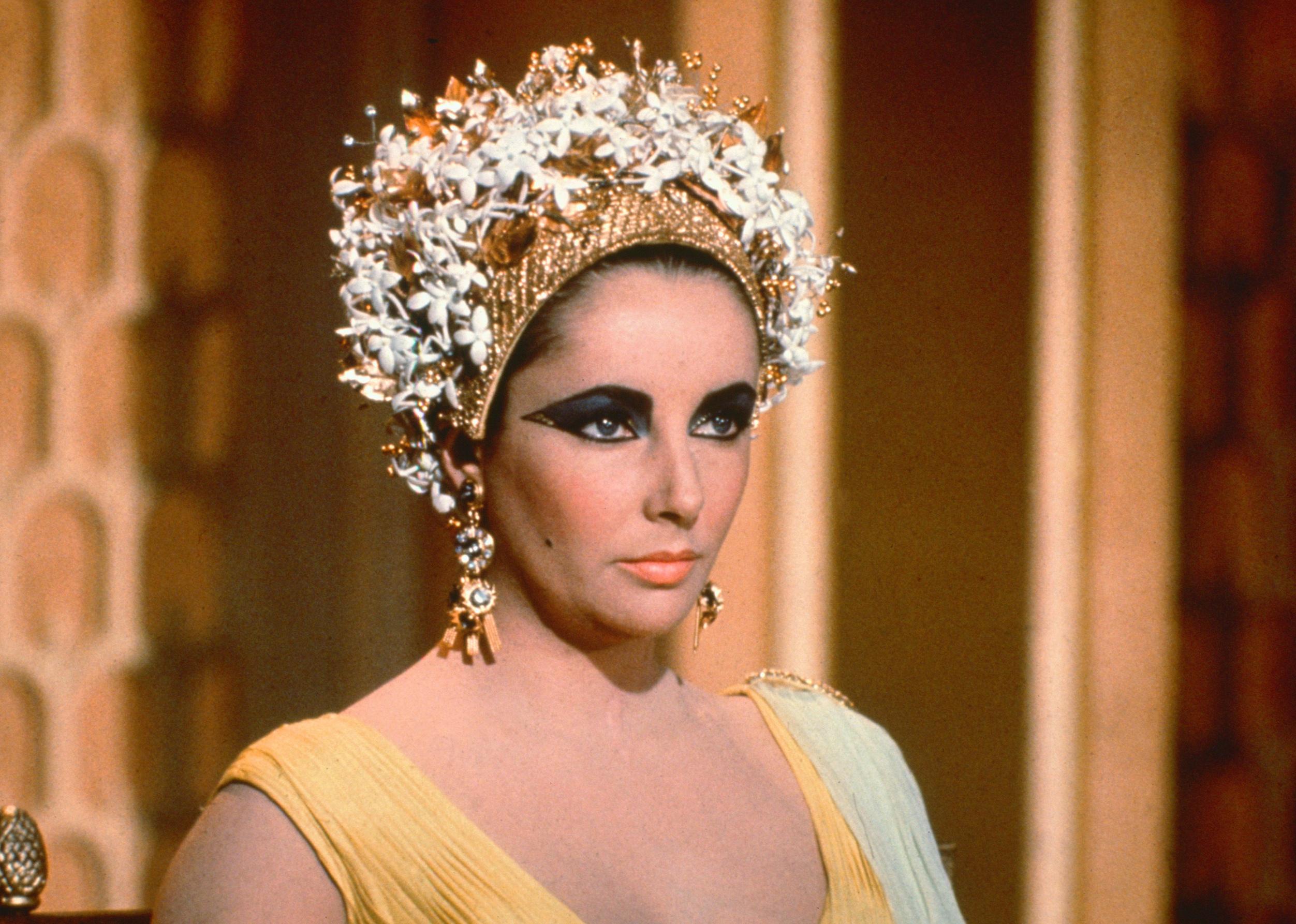 Elizabeth Taylor in costume with gold jewellery in a publicity still for the film, Cleopatra, 1963.