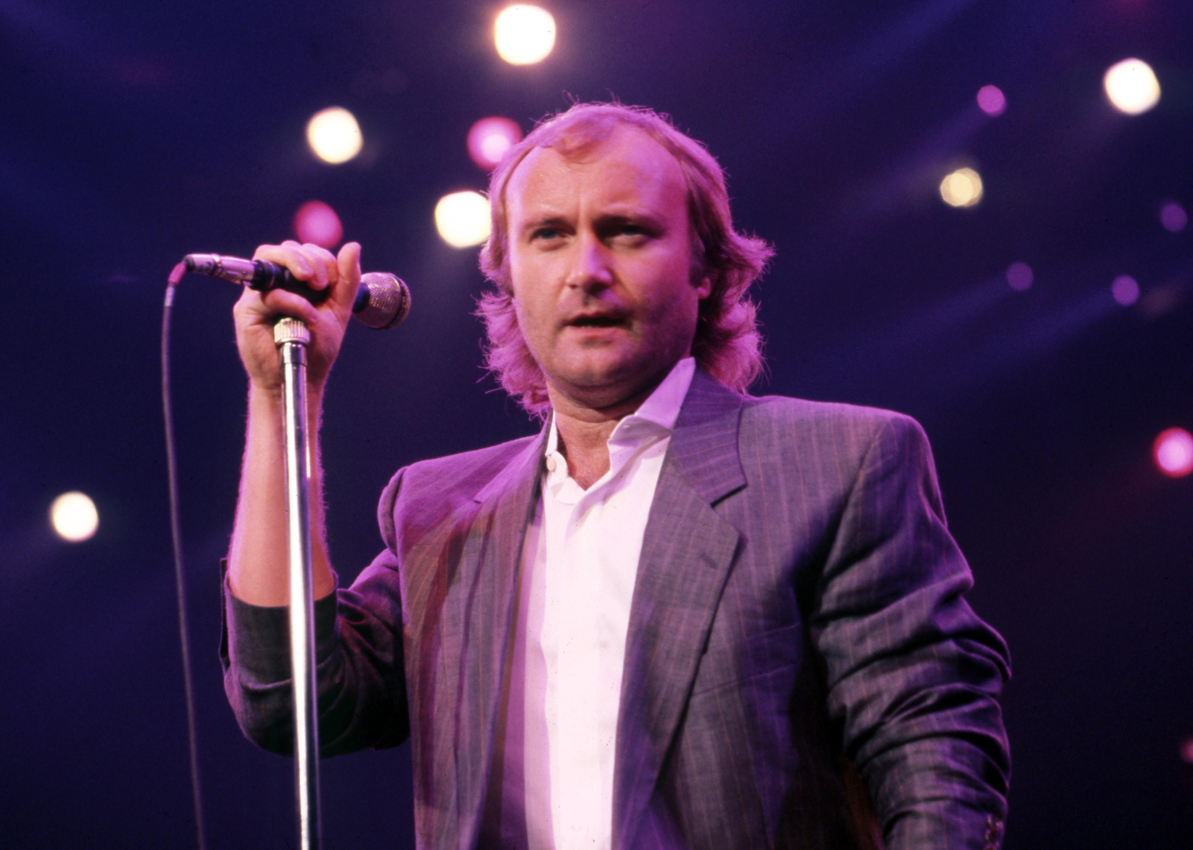 Phil Collins performing on stage.
