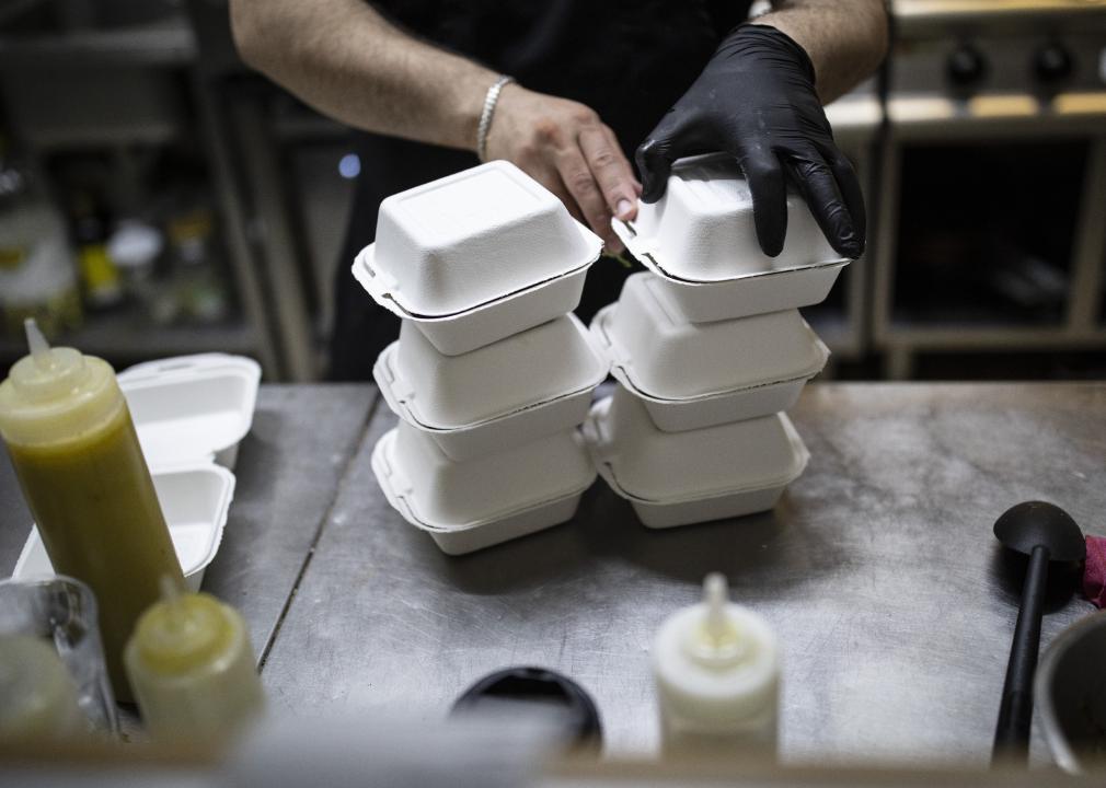 Cook packs food order for online delivery in a commercial kitchen.