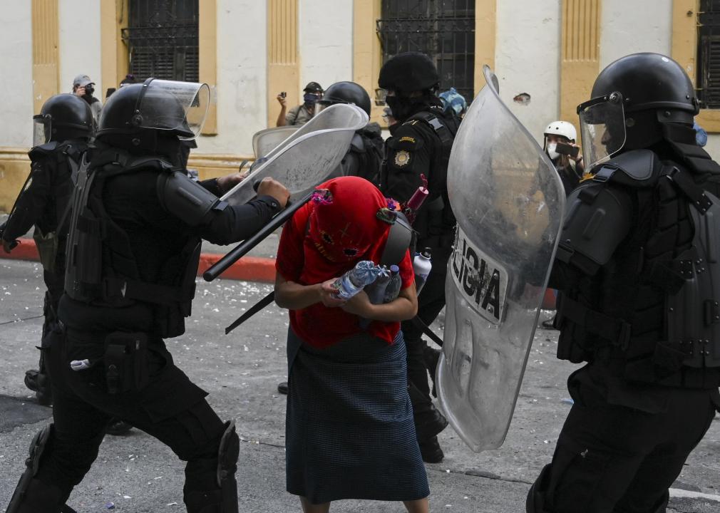 Riot police attack a demonstrator during a protest