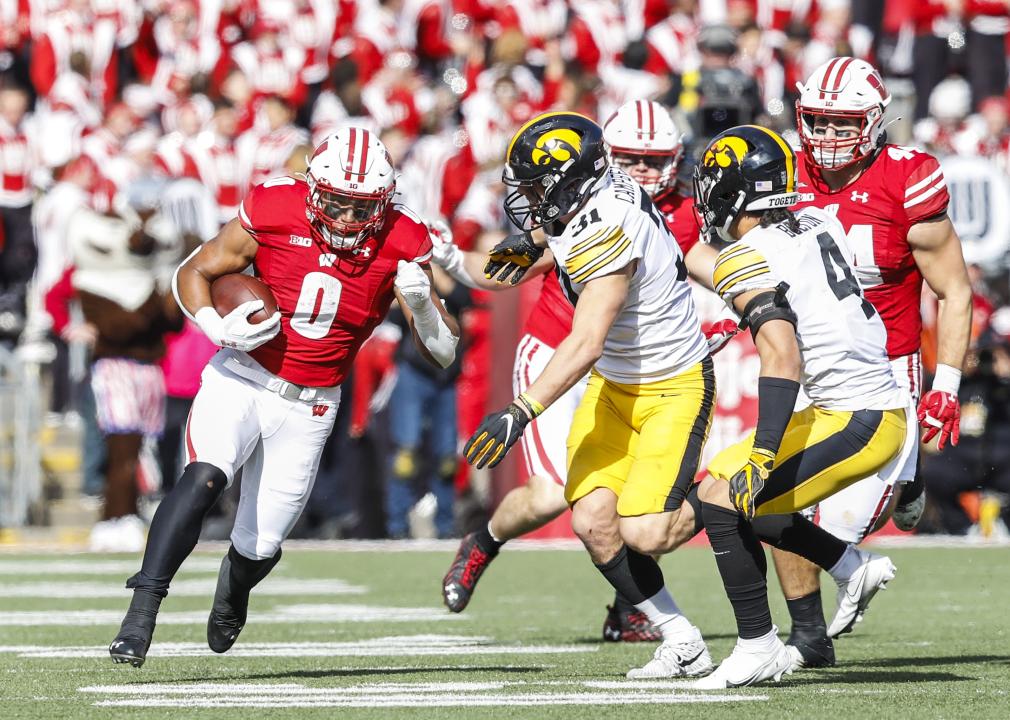 Wisconsin running back Braelon Allen tries to get past Iowa line backer Jack Campbell and Iowa defensive back Dane Belton during a game