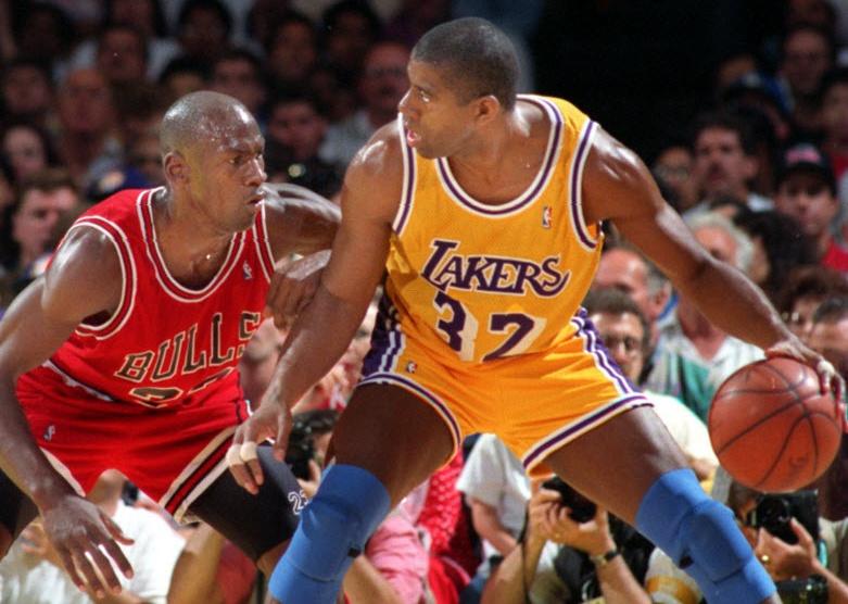 Earvin Johnson tries to move past Michael Jordan