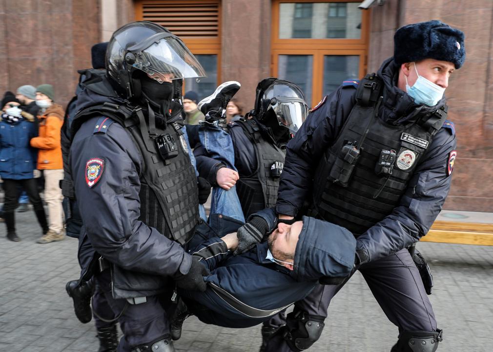 Russian Police officers detain a man during an unsanctioned protest