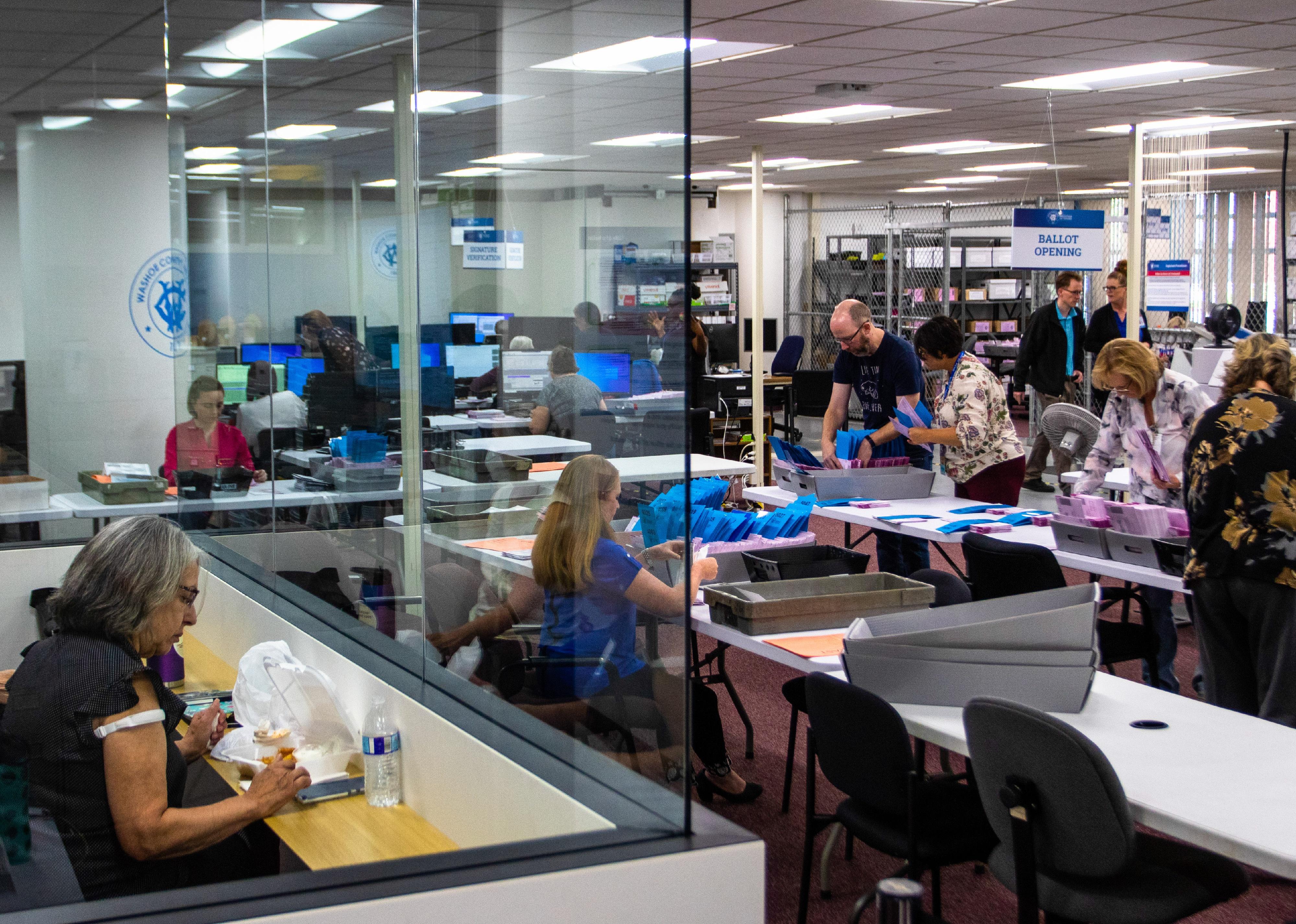 Observers watch ballots being counted from a sealed room