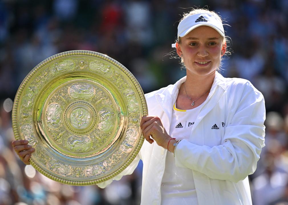 Elena Rybakina celebrates with the Venus Rosewater Dish trophy.