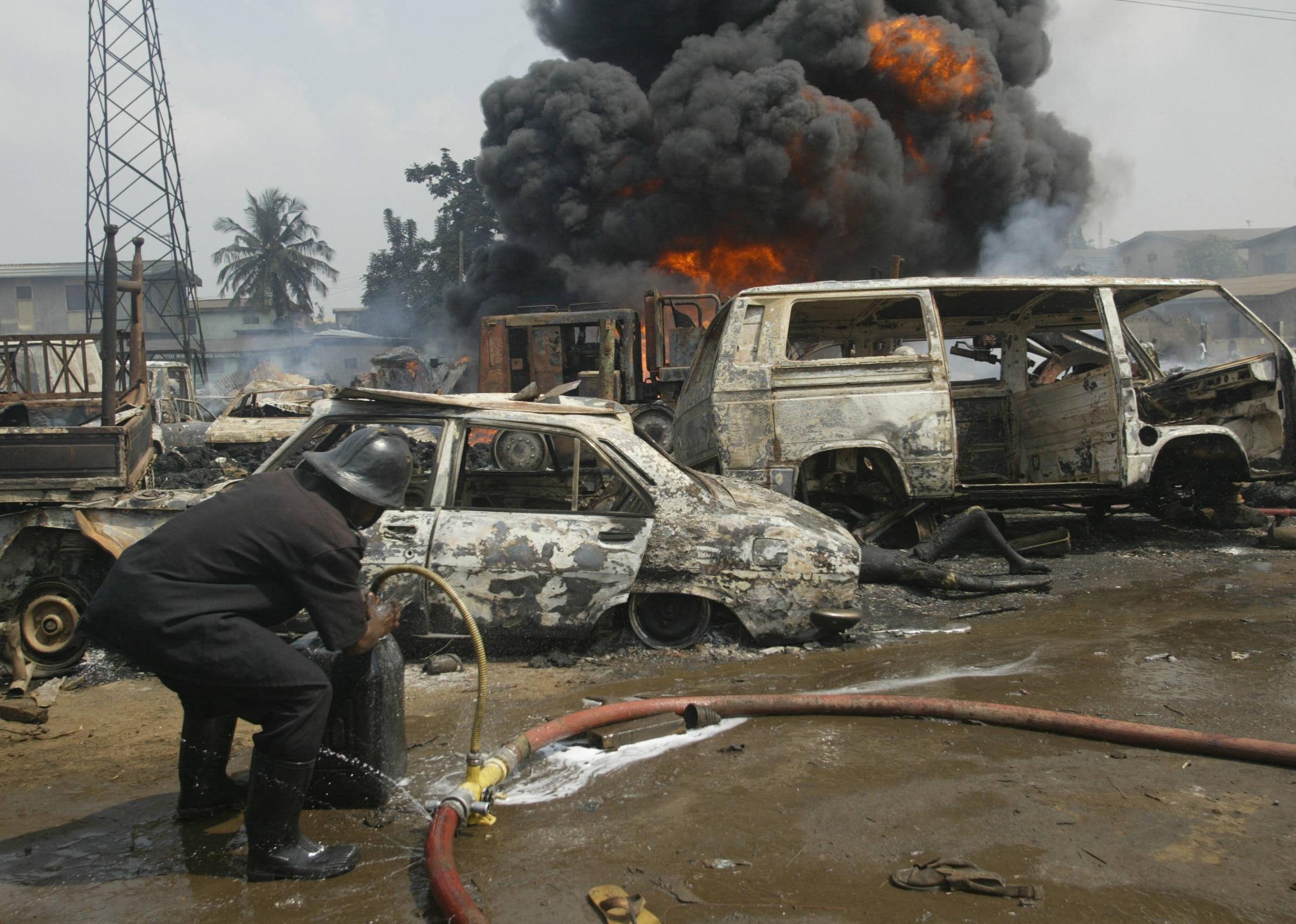 A firefighter tries to put off the fire at the scene of a pipeline explosion at Abule Egba.