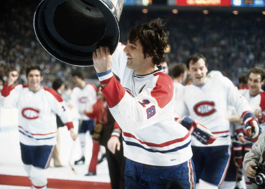 Serge Savard holds the Stanley Cup over his head 