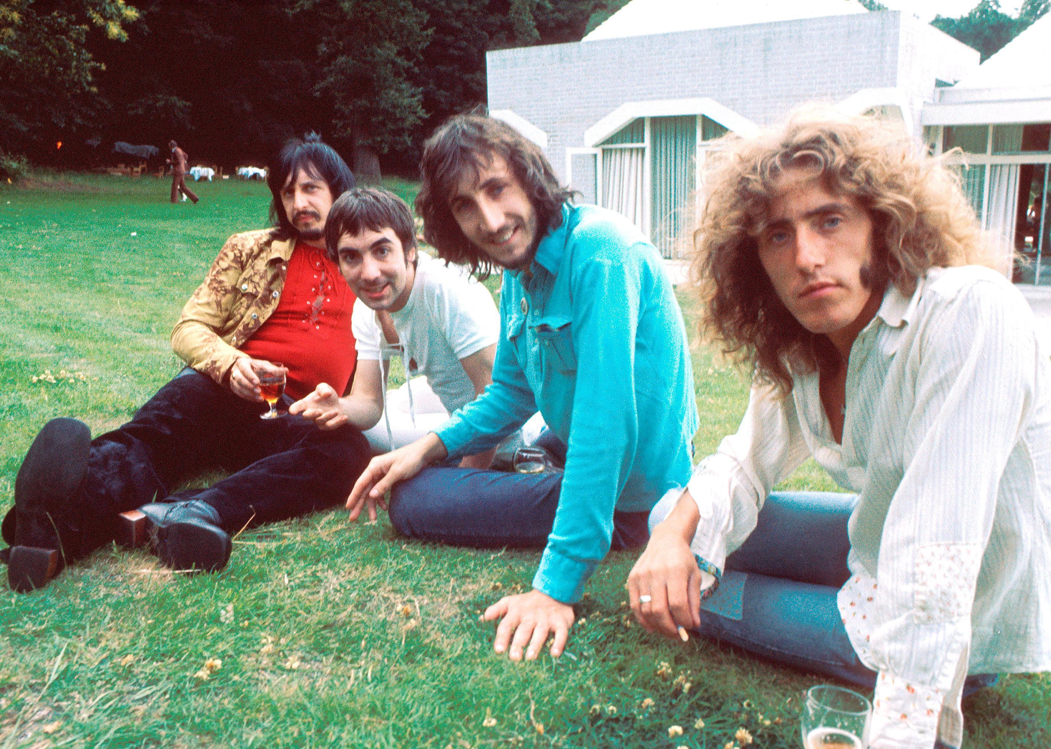 Posed group photo of the Who outside on lawn.