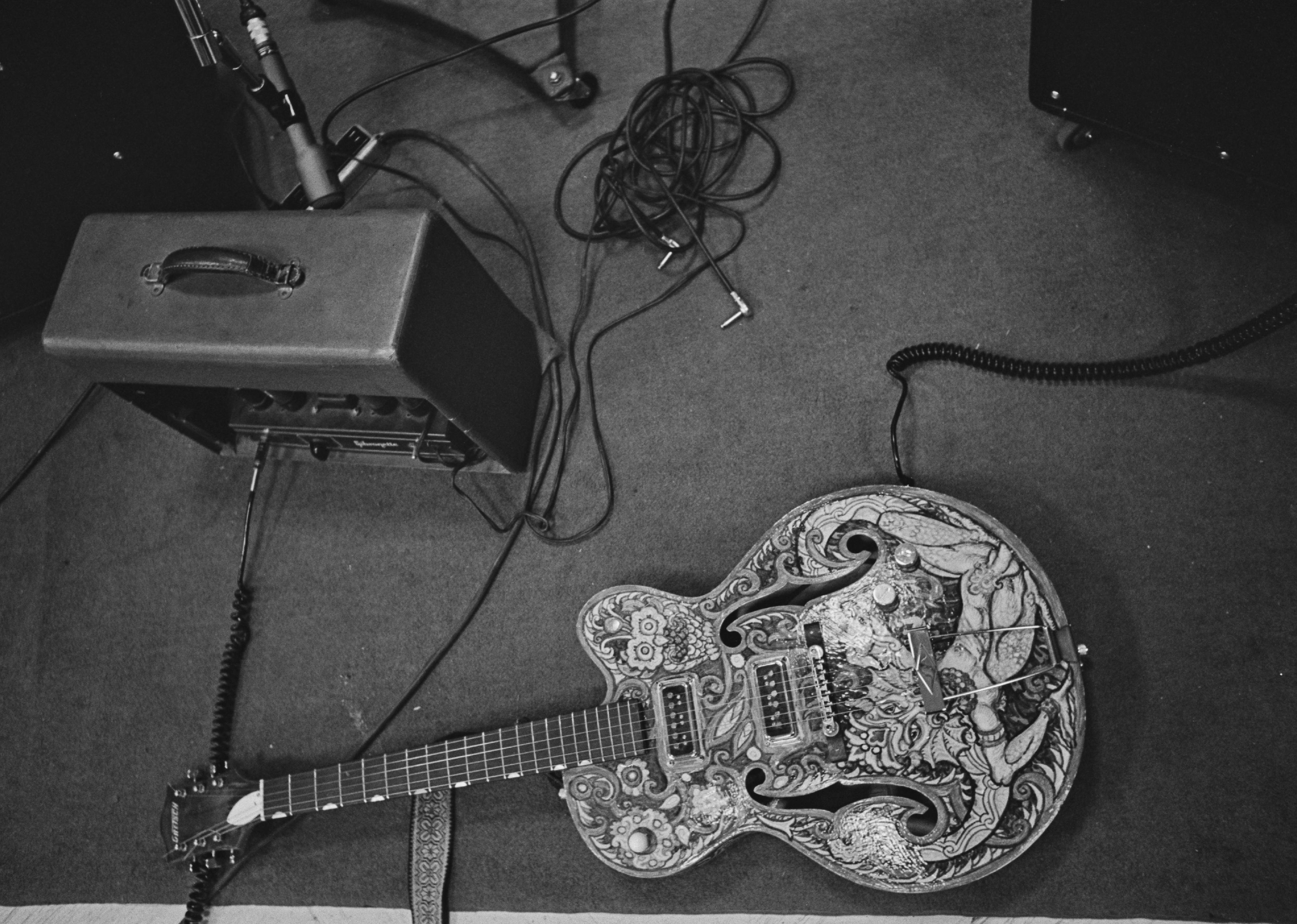 A decorated Gretsch 6120 guitar on the floor of a studio.