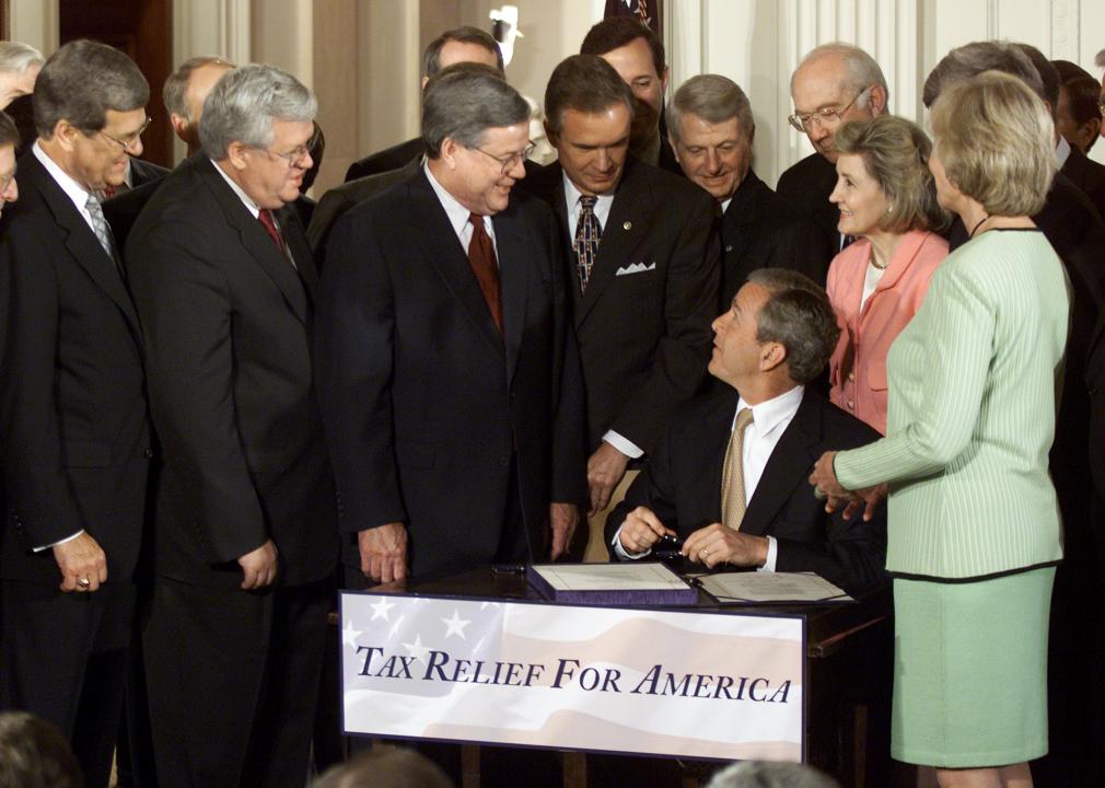 Surrounded by members of Congress, President George W. Bush signs a bill 