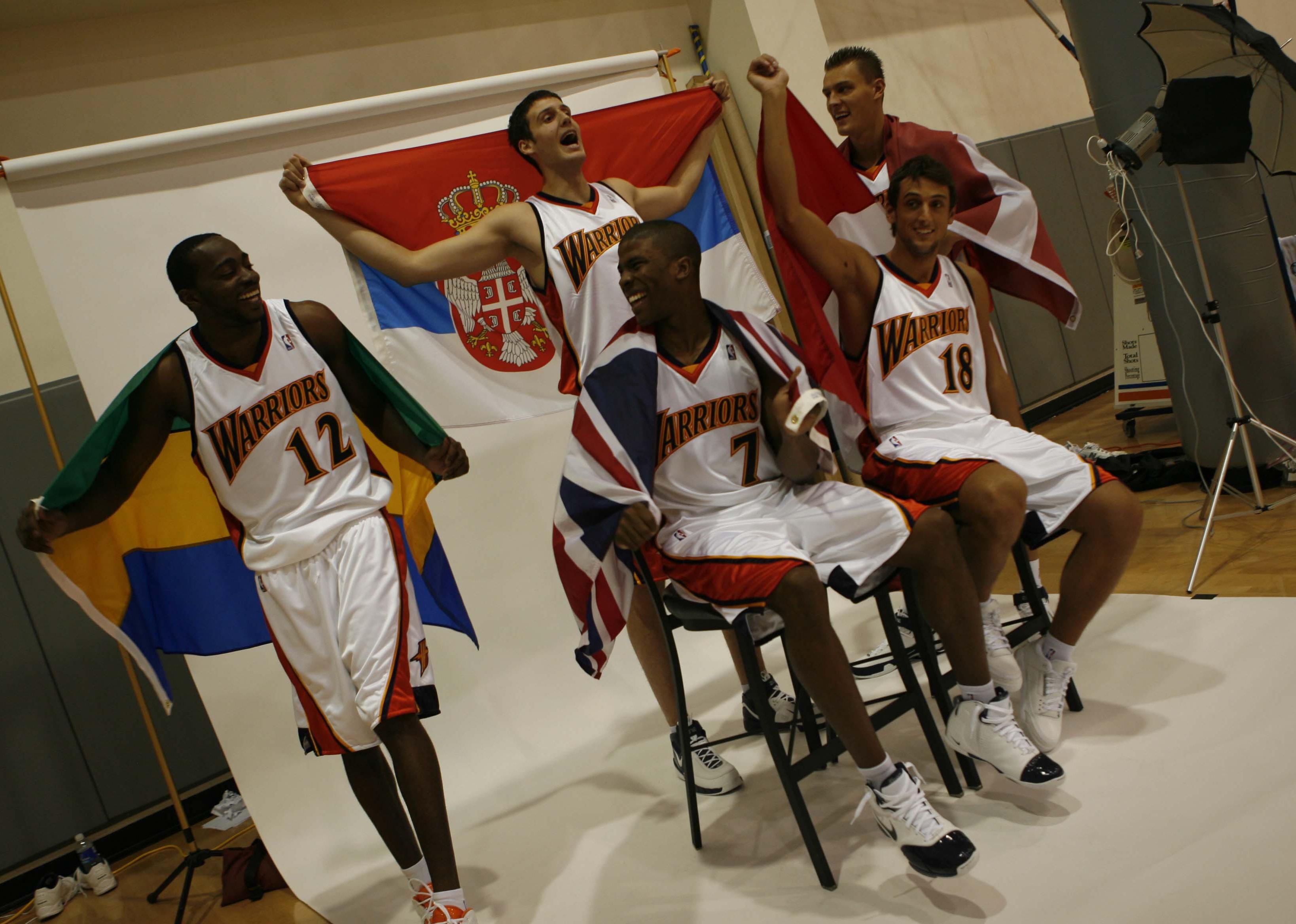 Stephane Lasme and others pose with their native country flags during Warriors media day. 