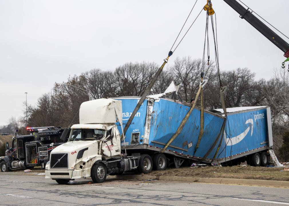 Tow truck with crane lifting crashed Amazon truck