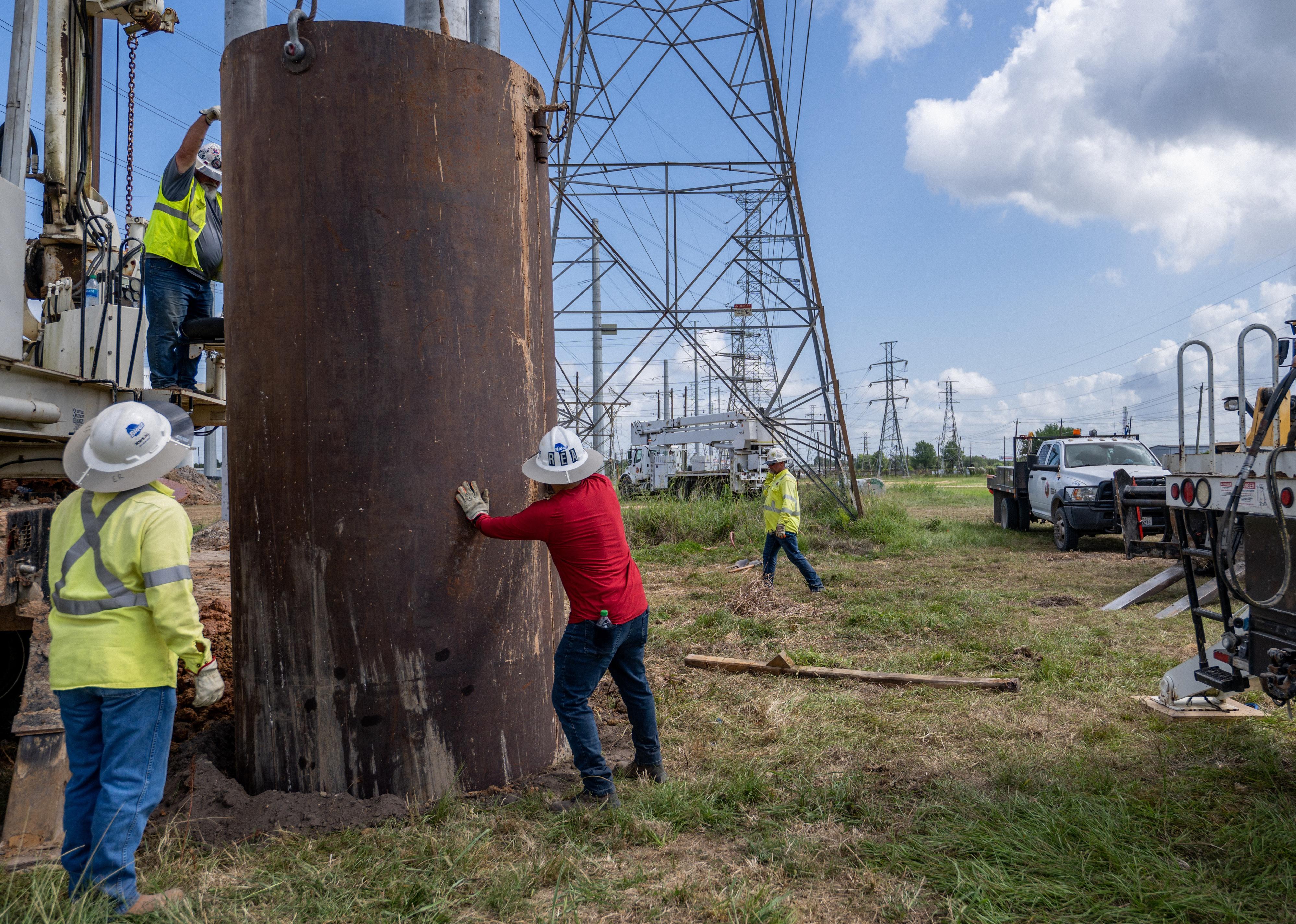 Service technicians work to install the foundation for a transmission tower.
