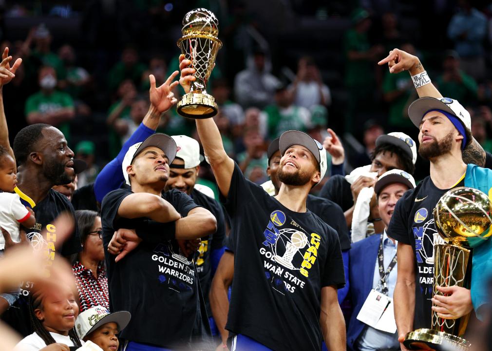 Stephen Curry #30 of the Golden State Warriors raises the Bill Russell NBA Finals Most Valuable Player Award.