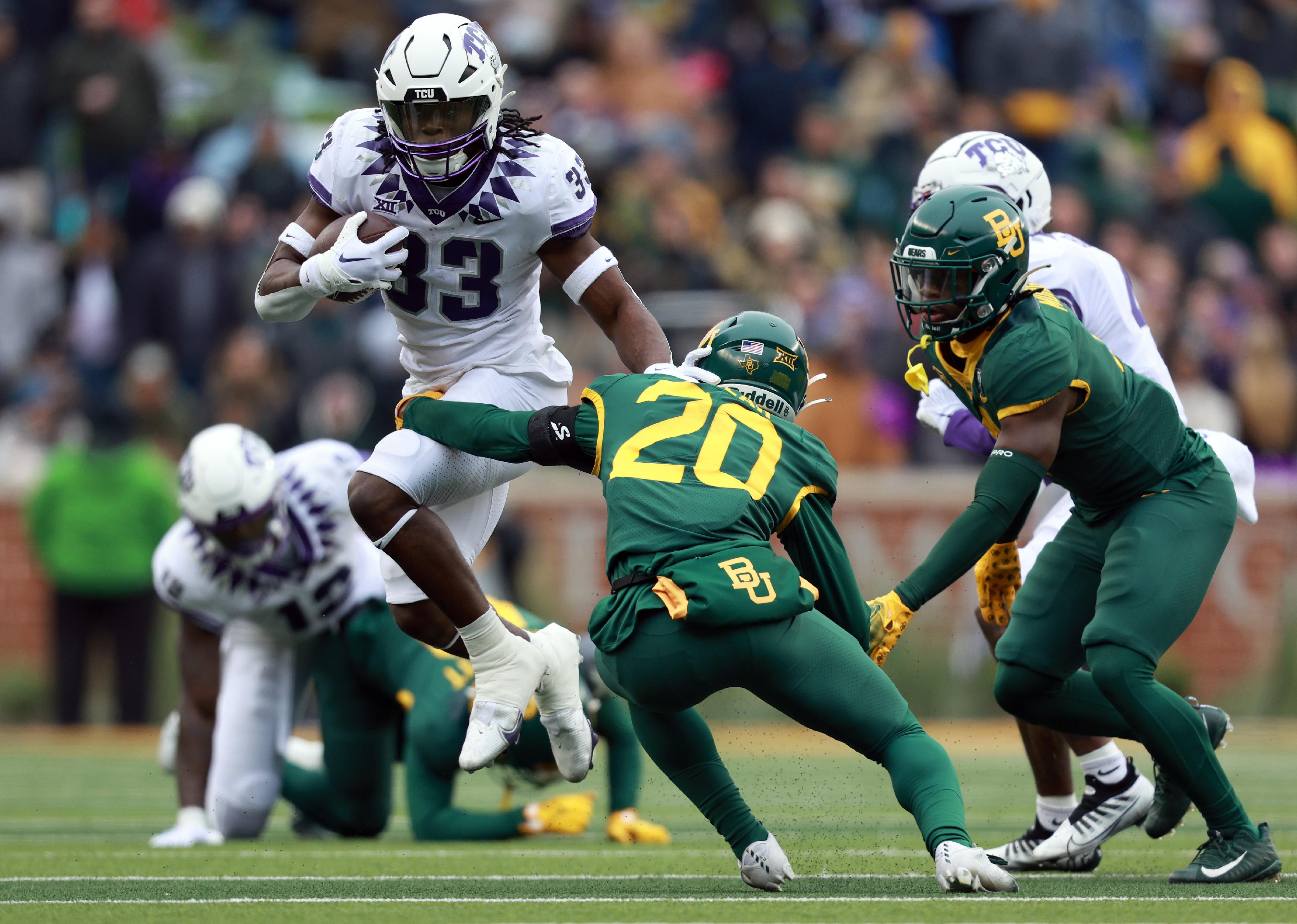 Running back Kendre Miller of the TCU Horned Frogs carries the ball against Baylor players.