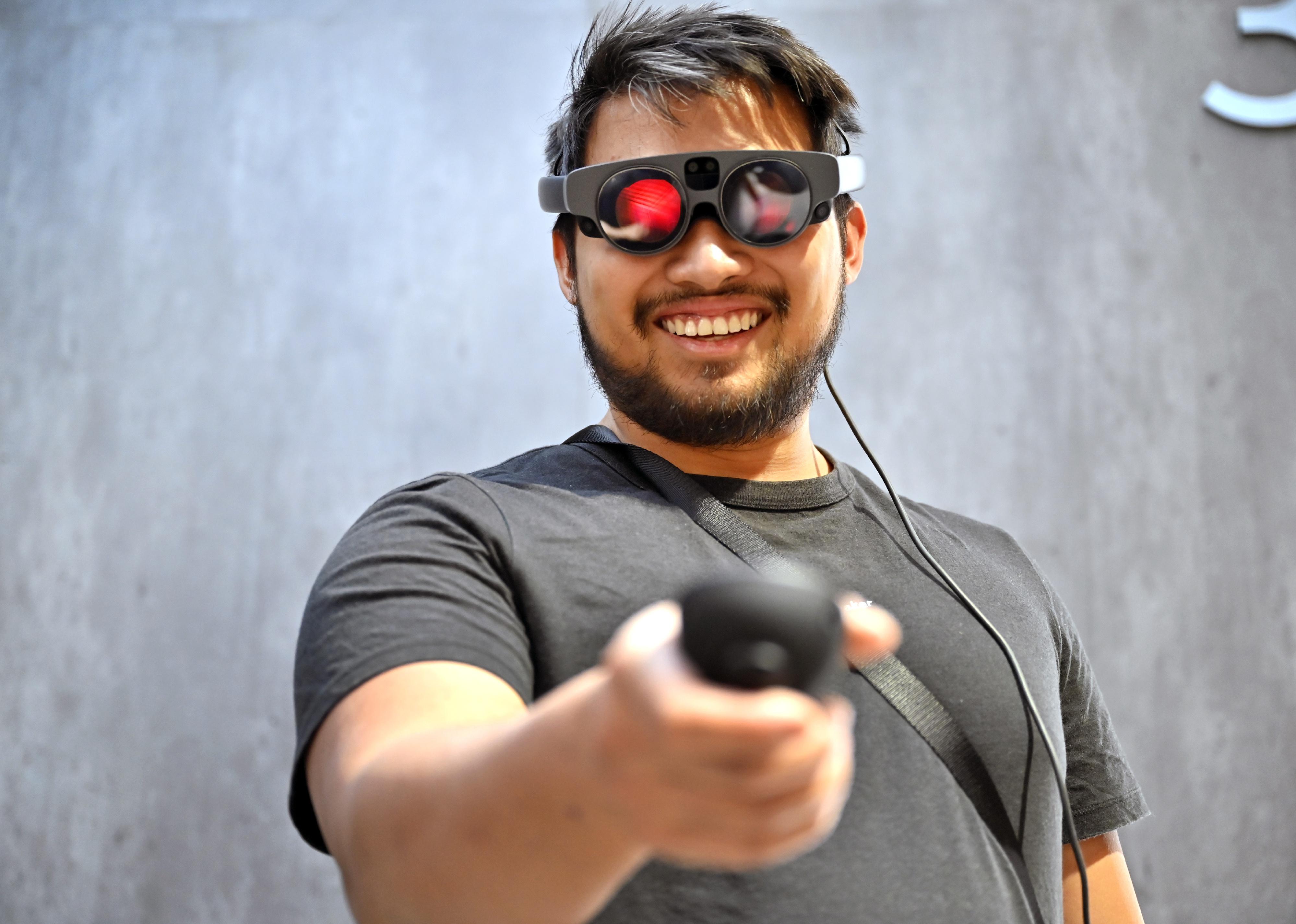 Attendee uses augmented reality (AR) glasses in a simulation at a Magic Leap booth.