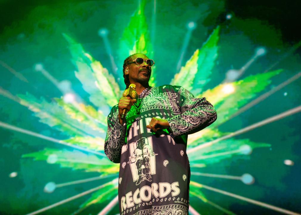 Snoop Dogg performs on stage with a large neon green cannabis leaf projected behind him at the OVO Hydro in Glasgow 2023.