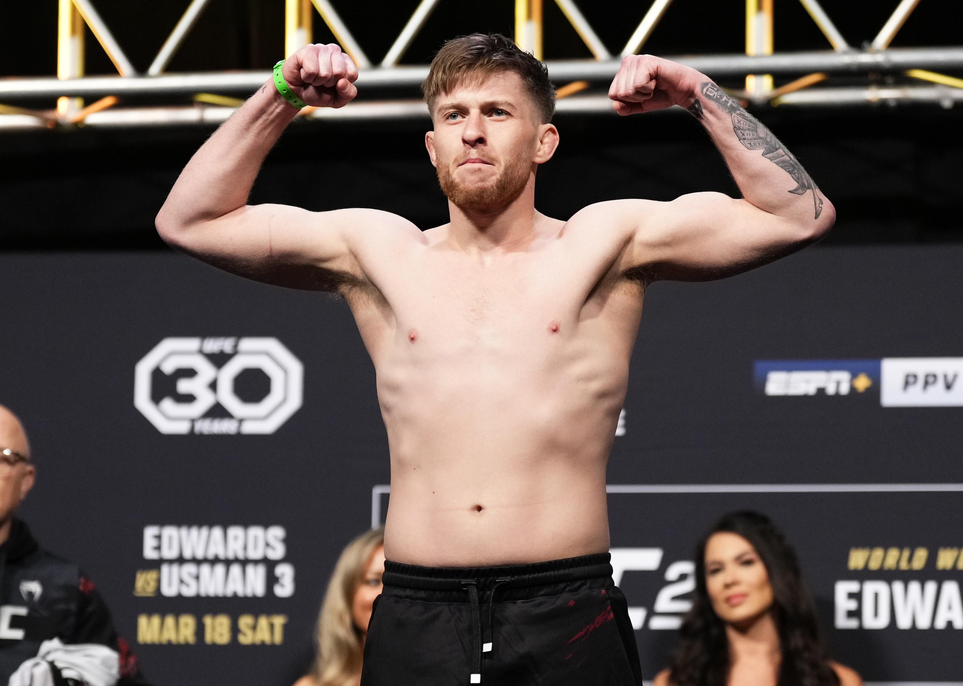 Jack Shore poses on the scale during the UFC 286 ceremonial weigh-in.